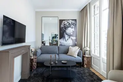 a living room with a blue couch and a tv at En Ville Boutique Apartments Calabria in Barcelona