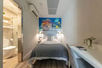 a bedroom with a bed and a painting on the wall at Standbyme Ramblas in Barcelona