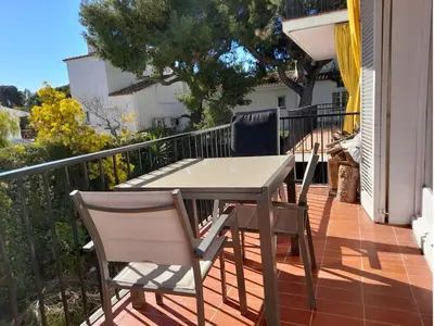 a table and two chairs on a balcony at Quiet cozy apartment near beach in Sitges