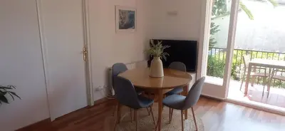 a dining room with a table and chairs and a television at Quiet cozy apartment near beach in Sitges