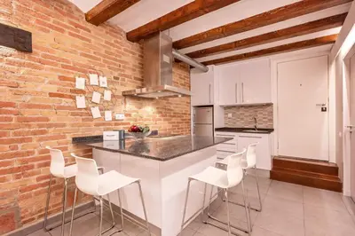 a kitchen with a white counter and a brick wall at Sweett - Gallery Poble Sec in Barcelona