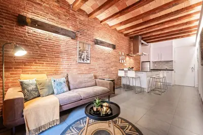 a living room with a couch and a brick wall at Sweett - Gallery Poble Sec in Barcelona