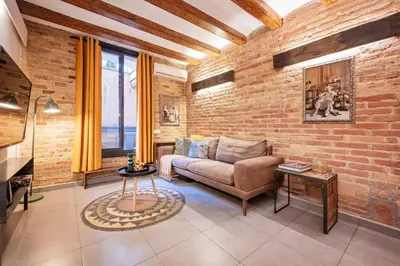a living room with a couch and a brick wall at Sweett - Gallery Poble Sec in Barcelona