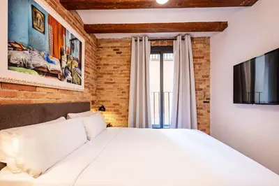 a bedroom with a white bed and a tv at Sweett - Gallery Poble Sec in Barcelona