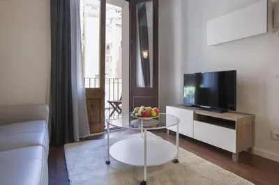 a living room with a glass table and a television at Tendency Apartments - Sagrada Familia in Barcelona