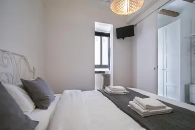 a white bedroom with a bed with towels on it at Tendency Apartments - Sagrada Familia in Barcelona