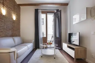 a living room with a couch and a tv at Tendency Apartments - Sagrada Familia in Barcelona