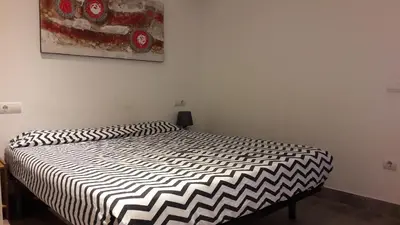 a bedroom with a bed with a black and white comforter at Fasten in Barcelona