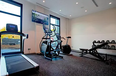 a room with a gym with a treadmill and a flat screen tv at Holiday Inn Express & Suites Barcelona - Sabadell by IHG in Sabadell