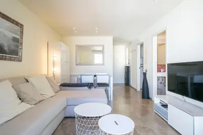 a living room with a couch and a tv and tables at Beach Penthouse in Sitges