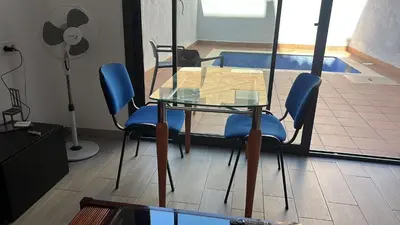 a glass table with blue chairs in a room at D&G casas in El Prat de Llobregat