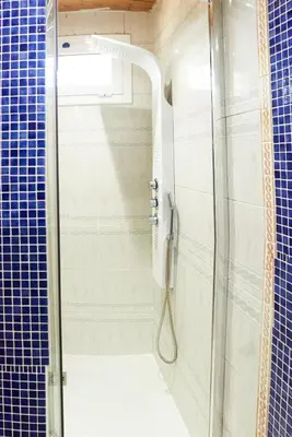 a bathroom with a shower with blue tiles at Casa en Sierra Collserola in Sant Cugat del Vallès