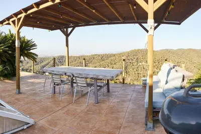 a table and chairs on a patio with a view at Casa en Sierra Collserola in Sant Cugat del Vallès