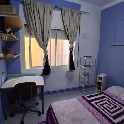 a bedroom with a window with a desk and a chair at Habitación azul con cama doble disponible en Barcelona in Barcelona