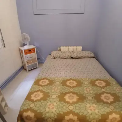 a small bedroom with a bed and a night stand at Habitación azul con cama doble disponible en Barcelona in Barcelona