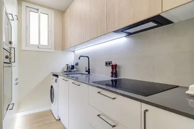a kitchen with white cabinets and a sink at GuestReady- Lovely apartment in Barcelona in Barcelona