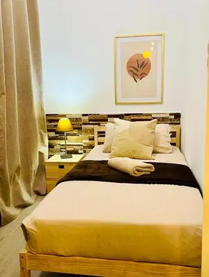 a bedroom with a large bed with white sheets and pillows at Basic interior Apartment Sagrada Familia Excellent for exploring Barcelona Very good location in Barcelona