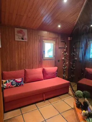 a red couch in the corner of a room at Can Marisu, Casita privada in Cabrils