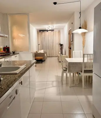 a kitchen and living room with a table and a dining room at Acojedor apartamento, centro con patio in Sabadell