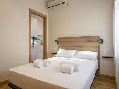 a bedroom with a white bed with towels on it at Winahost Sabadell Buxeda in Sabadell