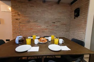 a wooden table with plates of food and glasses of orange juice at Cozy Equipped Duplex in Poblenou Ideal for 4 Guests and Close to Public Transport in Barcelona