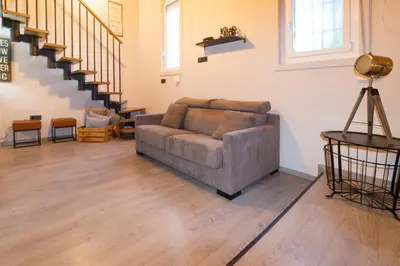 a living room with a couch and a staircase at Cozy Equipped Duplex in Poblenou Ideal for 4 Guests and Close to Public Transport in Barcelona