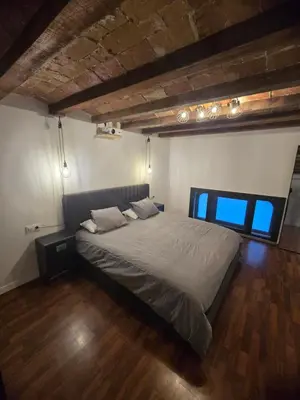 a large bed in a room with a wooden floor at Industrial loft in Eixample near Sagrada familia in Barcelona