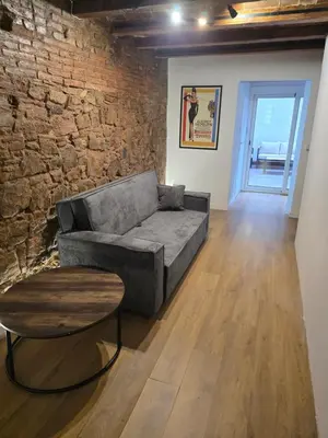 a living room with a couch and a brick wall at Industrial loft in Eixample near Sagrada familia in Barcelona