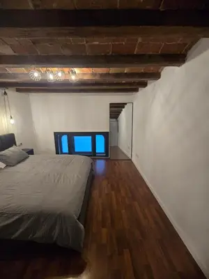 a bedroom with a bed and a wooden floor at Industrial loft in Eixample near Sagrada familia in Barcelona