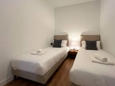 two beds in a room with white walls at Stay U-nique Apartments Balmes III in Barcelona