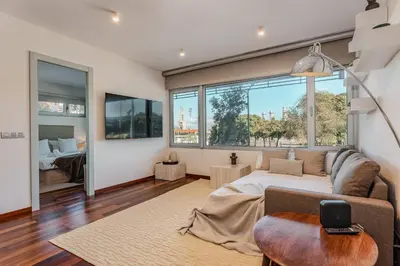 a living room with a couch and a large window at Beachside apartment in Barcelona