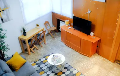 a living room with a couch and a tv and a table at Casa la Luna in Badalona