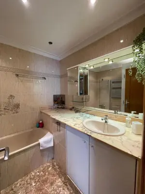 a bathroom with a sink and a tub and a mirror at Casa la Luna in Badalona