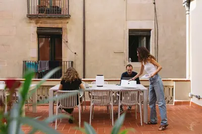 a woman sitting in a chair with a laptop at Outsite Barcelona in Barcelona