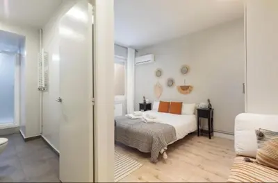 a white bedroom with a bed and a bathroom at Diagonal Avenue Apartment in Barcelona