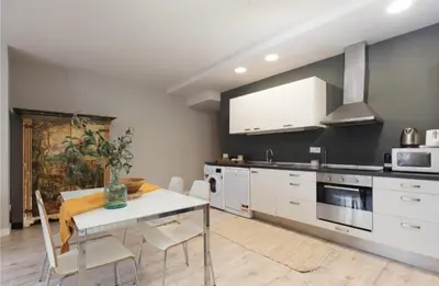 a kitchen with a table and chairs in a room at Diagonal Avenue Apartment in Barcelona