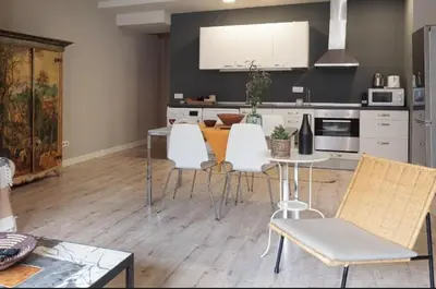 a kitchen with a dining table and white chairs at Diagonal Avenue Apartment in Barcelona