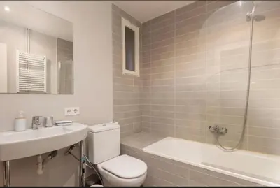 a bathroom with a toilet and a sink and a tub at Diagonal Avenue Apartment in Barcelona