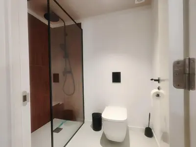 a bathroom with a toilet and a glass shower at Mazi Plaça Gran in Mataró