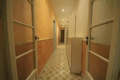 a corridor of a bathroom with a row of stalls at Plaza España Central Apartment in Barcelona