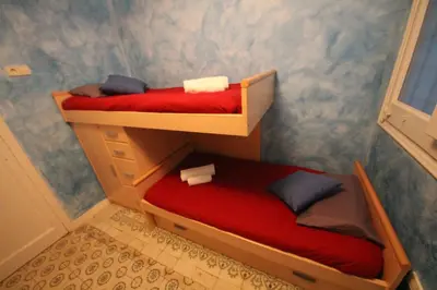 a room with two bunk beds with red sheets at Plaza España Central Apartment in Barcelona