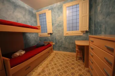 a small bedroom with a bunk bed and a desk at Plaza España Central Apartment in Barcelona