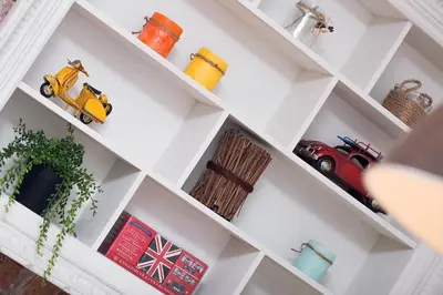 a white shelf with toy cars on it at Bright Industrial Loft Barcelona Center in Barcelona