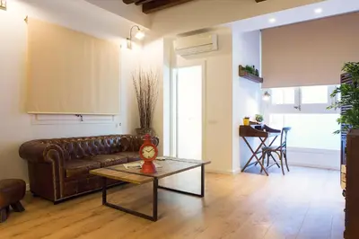 a living room with a leather couch and a table at Bright Industrial Loft Barcelona Center in Barcelona
