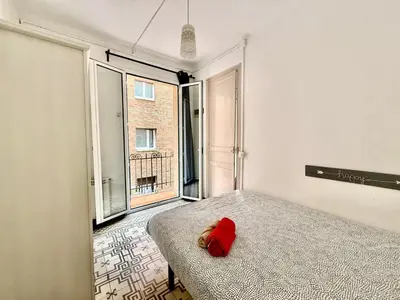 a bedroom with a bed with a red pillow on it at Bright 3 Bedroom Apartment Central Barcelona in Barcelona