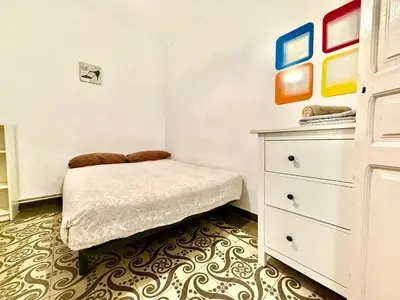 a small bedroom with a bed and a dresser at Bright 3 Bedroom Apartment Central Barcelona in Barcelona