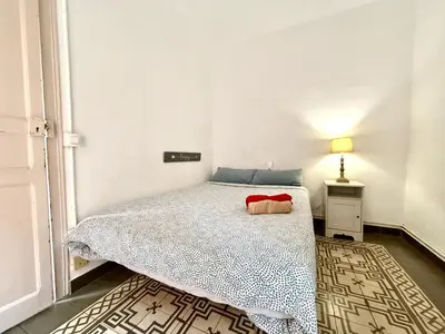 a small bedroom with a bed and a lamp at Bright 3 Bedroom Apartment Central Barcelona in Barcelona