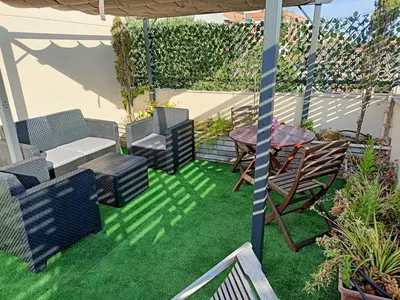 a patio with chairs and a table on grass at La Cantonada in Sant Pere de Ribes