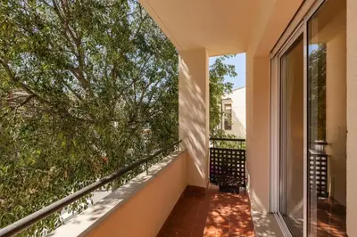 a balcony with a large window and a tree at La Cantonada in Sant Pere de Ribes