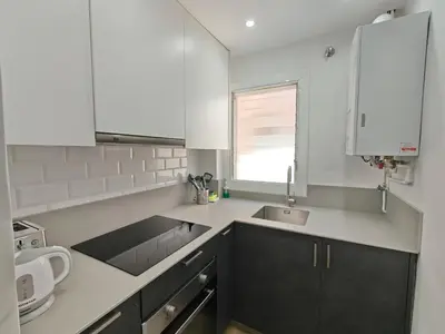 a kitchen with white cabinets and a sink and a window at Elegant apartment Sagrada Familia in Barcelona